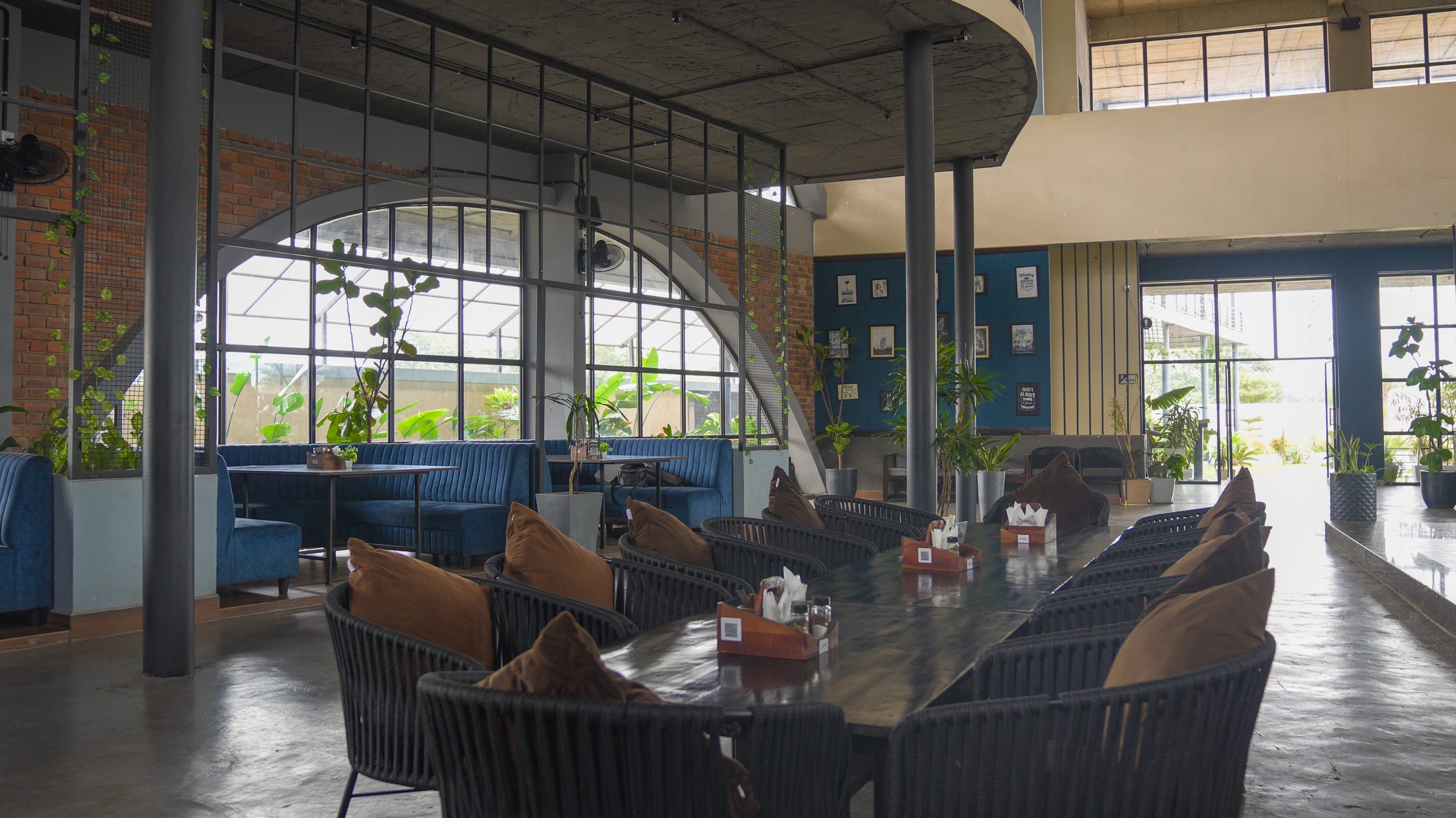 Lounge seating beside tall arched windows at Belagavi Brewing Company