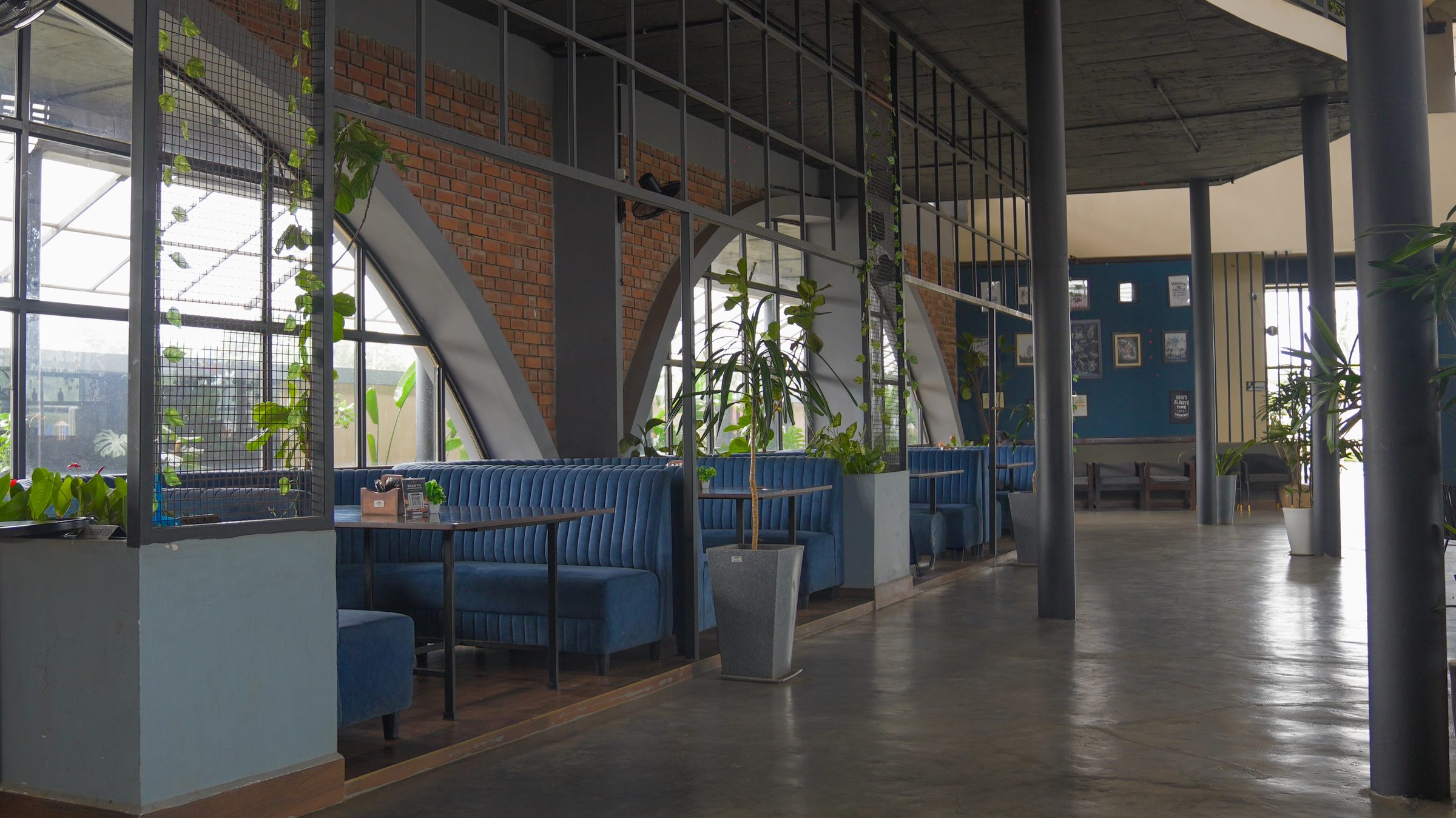 Blue booth seating by the arched windows at Belagavi Brewing Company
