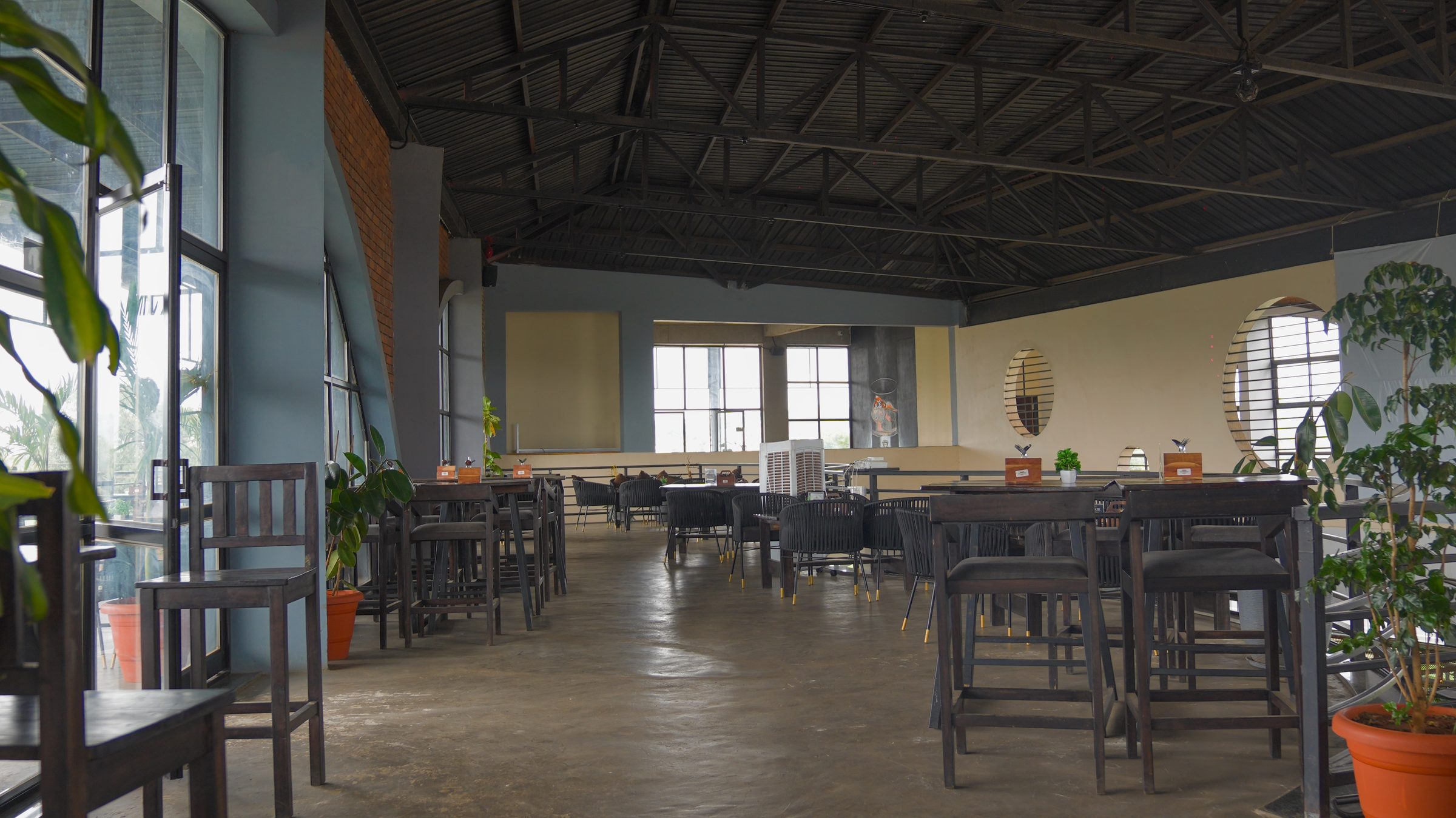 Large dining hall with wooden tables at Belagavi Brewing Company